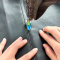 Accessories for old-style household treadle sewing machines: plastic roller presser foot and needle set.