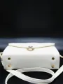 white coloured strap bag. 