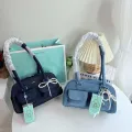 Cicelle shoulder bag oven modern denim fabric with Pearl knot pendant. 