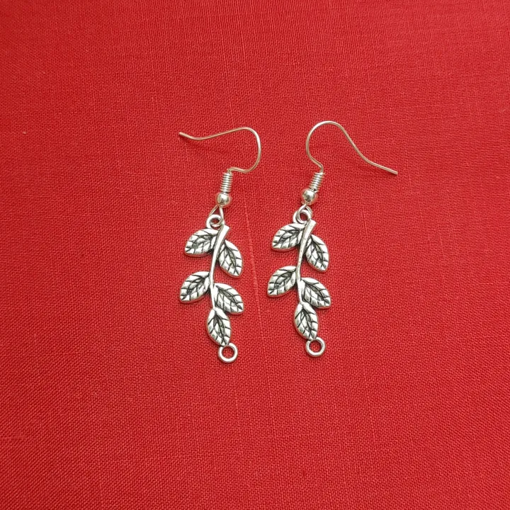 This is a Leaf design earring made of white metal that looks like ...