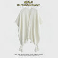 The new solid color cut-out decoration knitted ethnic shawl with furball cape and tassel in summer is a designer model.