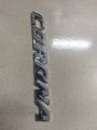 CORONA" chrome emblem, likely for a car. This is a car monogram or badge, commonly used on Toyota Corona vehicles.. 