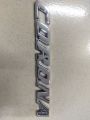 CORONA" chrome emblem, likely for a car. This is a car monogram or badge, commonly used on Toyota Corona vehicles.. 