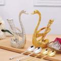 Gold spoon holder in the shape of a duck with a set of 6 fancy spoons.