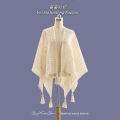 The new solid color cut-out decoration knitted ethnic shawl with furball cape and tassel in summer is a designer model.