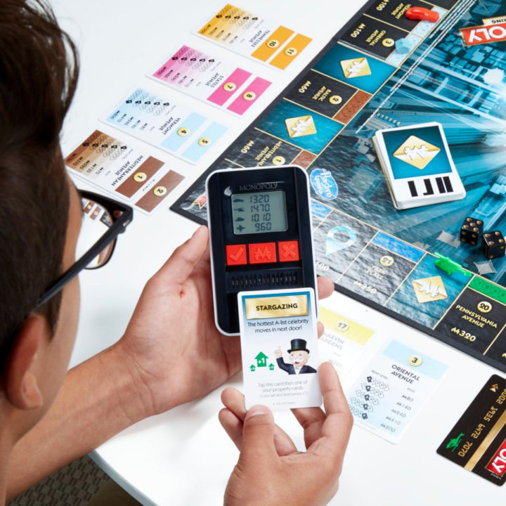 New%20Monopoly%20bord%20game%20Super%20Electronic%20Board%20Game,%20Electronic%20Banking%20Unit,%20Choose%20Your%20Rewards,%20Cashless%20Gameplay%20Tap%20Technology,%20for%20Ages%208%20and%20Up,Box%20English%20electronic%20monopoly%20-%20Image%205