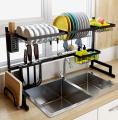 Double sink stainless steel dish drying rack over sink with cutlery holder. 