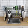 Double sink stainless steel dish drying rack over sink with cutlery holder. 