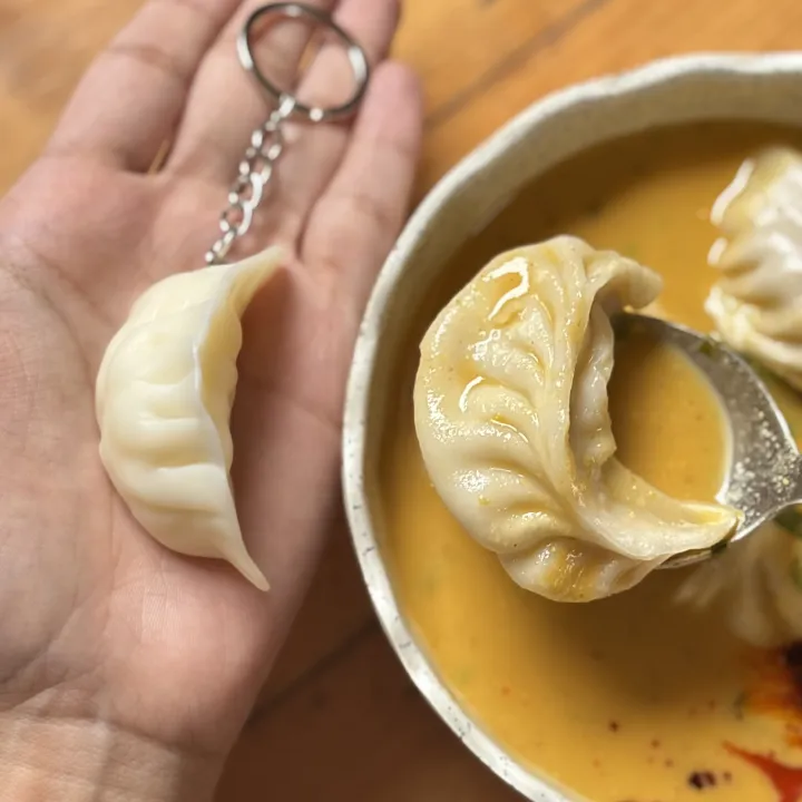 Mini%20Momo%20Dumpling%20Keyring%20%E2%80%93%20Cute%20Food-Themed%20Keychain,%20Acrylic/Resin%20Hanging%20Charm%20Accessory%20for%20Keys,%20Bags%20&%20Gifts%20%7C%20Momo%20Key%20Chain%20-%20Image%202