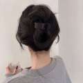 Simple solid color for women with design hair clip at back of the head featuring trendy internet celebrity bun hairstyle and a high ponytail accessory.