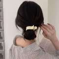 Simple solid color for women with design hair clip at back of the head featuring trendy internet celebrity bun hairstyle and a high ponytail accessory.