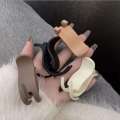 Simple solid color for women with design hair clip at back of the head featuring trendy internet celebrity bun hairstyle and a high ponytail accessory.