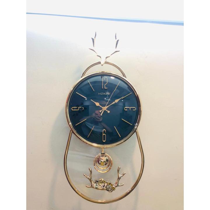 NEW 3D GLASS WALL CLOCK WITH SCREW HORN GOAT STRUCTURE ON TOP AND ROUND GLASS BOTTOM WITH PENDULUM FANCY AND ATTRACTIVE CLOCK IN BLACK GOLD COLOUR STYLISH DESIGN SMOOTH MACHINE WALL CLOCK HANGING WALL CLOCK HOME DECORATION PERFECT FOR YOUR LIVING ROOM