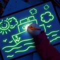 2 in 1 Magic Light Up Painting Drawing Board For Kids Portable Handwriting Toys For Boys & Girls Draw Sketch Art Educational Learning Drawing Slate For Kid Tracing Pad With Stickers & LED Pen Effect Glow In The Dark Art Doodle Color Fluorescent Sketchpad. 